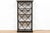 A tall, open-frame étagère or display shelf in a Hollywood Regency style and finished in ebonized black with gilt-edged...