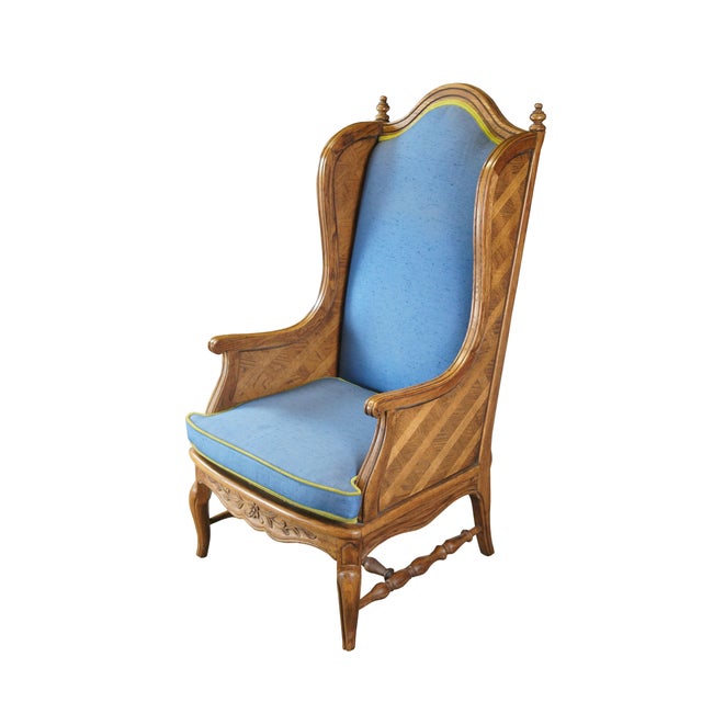 A stately wingback chair by Thomasville Furniture, Circa 1970s. Features an oak frame with a serpentine crest rail set...