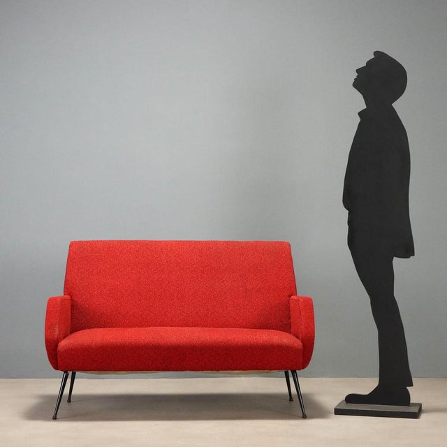 1960s vintage settee featuring a minimalist and functional design typical of the era. The structure is supported by...