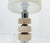 Architectural table lamp composed of stacked travertine discs separated by cylindrical chrome-plated metal elements. A...
