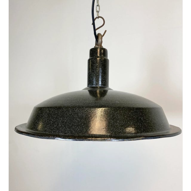 Industrial hanging light made in the 1950s. Dark grey enamel. White interior. Iron top. New porcelain socket for E27 light...