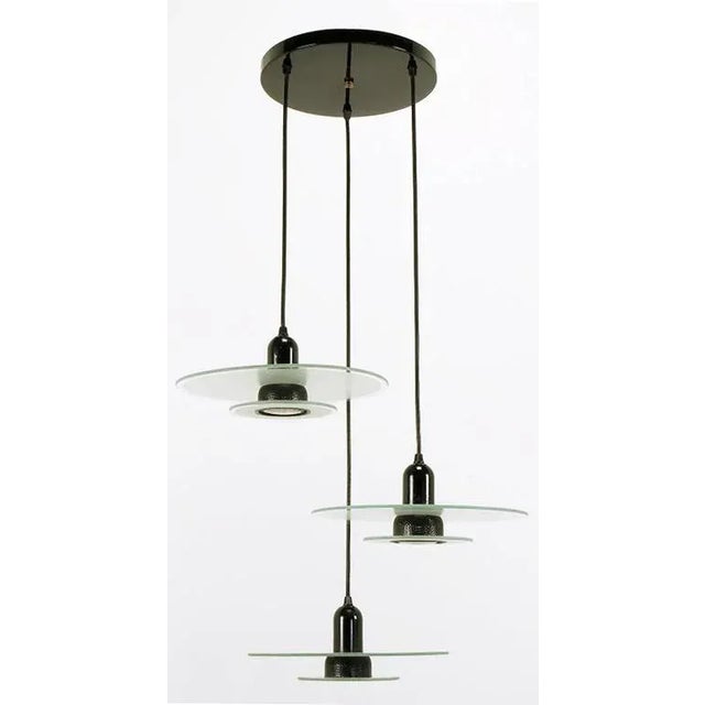 Art Deco revival three-light pendant fixture with etched and clear two part glass disc shades. Black enamel steel bullet...