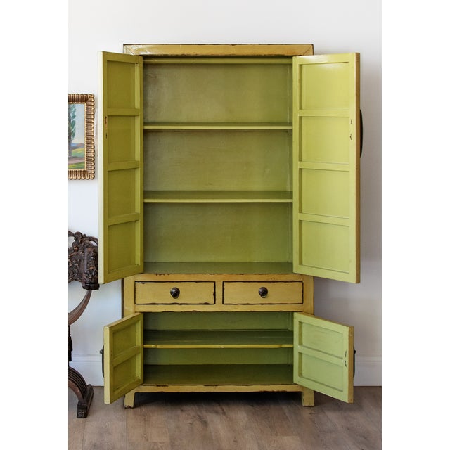 A fantastic Chinese distressed citron yellow lacquered cabinet. Supported on four squared legs with lower case having two...