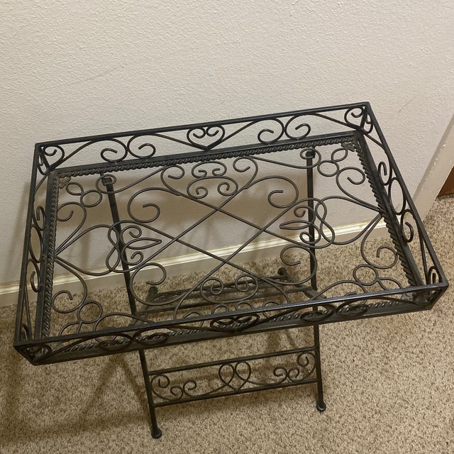 This table features a vintage or Spanish Revival inspired design with intricate scroll patterns on top and base.