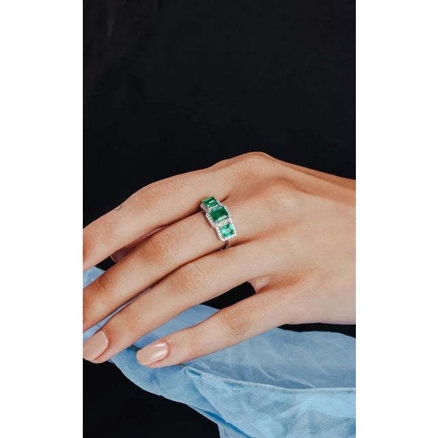 This is part of Chairish’s Fine Jewelry assortment. Three Stone Genuine Emerald Ring with Halo Diamond Set in 18K Gold...
