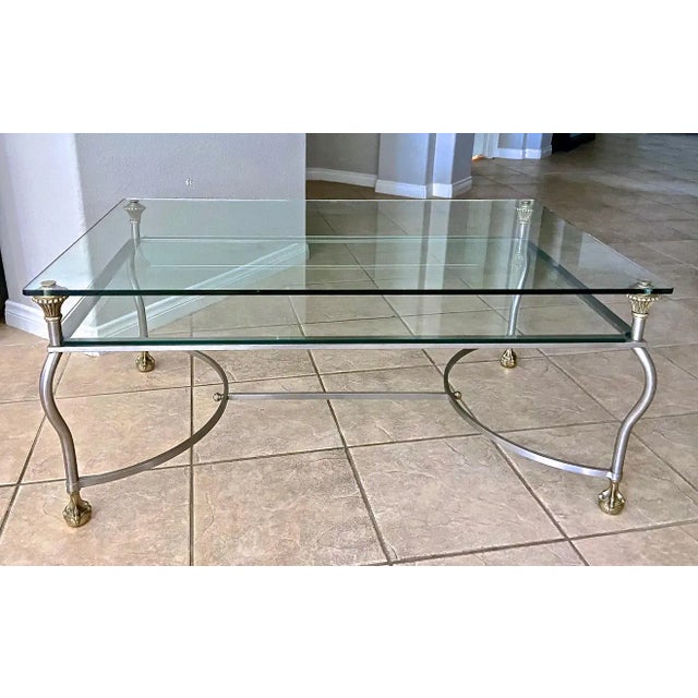 Italian made steel and brass two tier glass inset cocktail table with claw feet detailing. The well constructed table...