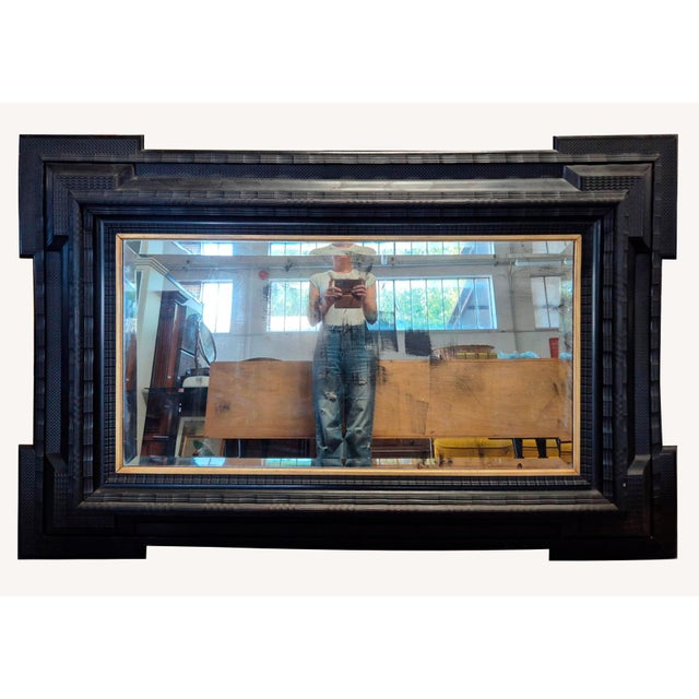 An exceptional large ebonized wood wall mirror, Italy, late 19th century. The frame features stepped profiles of...