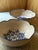 A pair of hand-thrown stoneware bowls, each shaped with a distinctive scalloped, petal-like rim finished in cobalt blue....