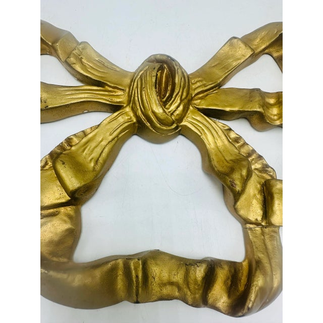This is a vintage decorative wall ornament in the form of a stylized ribbon bow. Design & Material • Form: The piece is...