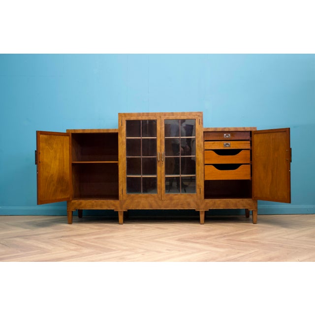 This high-quality mahogany Art Deco sideboard, circa 1930s. Featuring a glass door cupboard to the middle, with felted...