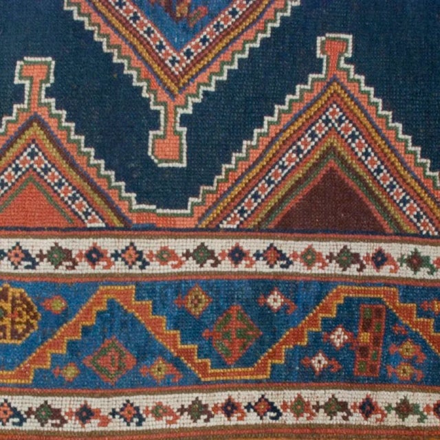 A 19th century Persian Azeri carpet with four diamond medallions on an indigo background surrounded by a complementary...