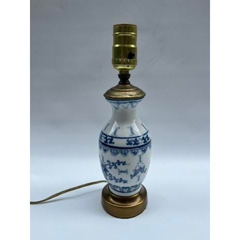 A single small Chinese export porcelain vase mounted as a table lamp on a gold metal base. The hand painted vase features...