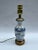 A single small Chinese export porcelain vase mounted as a table lamp on a gold metal base. The hand painted vase features...