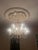 Large vintage crystal chandelier featuring elegant glass arms, faceted crystal prisms, and French Empire/Hollywood Regency...