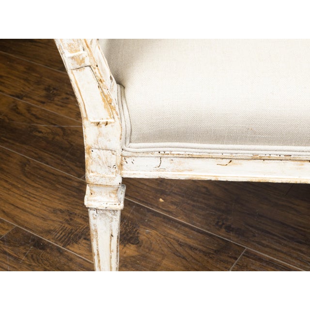 An Italian painted wood sofa from the 19th century, with two slanted sides, tapered carved legs and distressed patina....