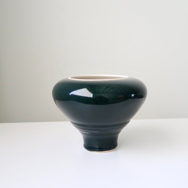 Signed handmade studio pottery vessel dated 1996, featuring a striking sculptural silhouette and rich, deep hunter green...