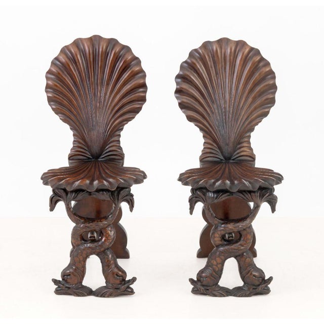 Pair of Italian Grotto Shell Carved Wood Chairs, with dolphin motif bases. 37.5" H x 16.5" W x 22" D; seat: 18" H....