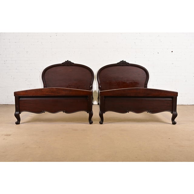 A gorgeous pair of antique French Provincial Louis XV style carved mahogany twin size bed frames In the manner of Romweber...