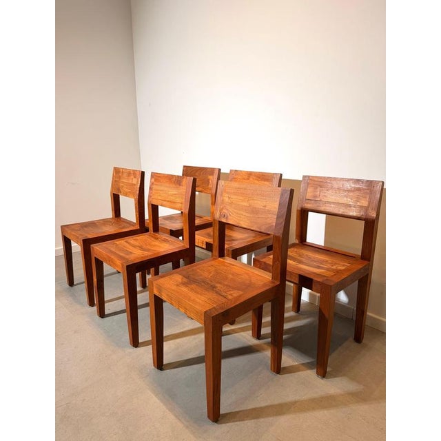A striking set of six solid teak dining chairs featuring a bold, architectural design. Crafted from beautifully grained...