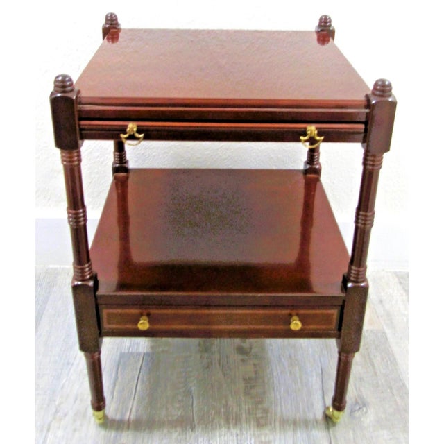 This 1980s Bombay Regency Style Cherry Finish Two Tier Side End Table is a stylish and functional piece of furniture for...