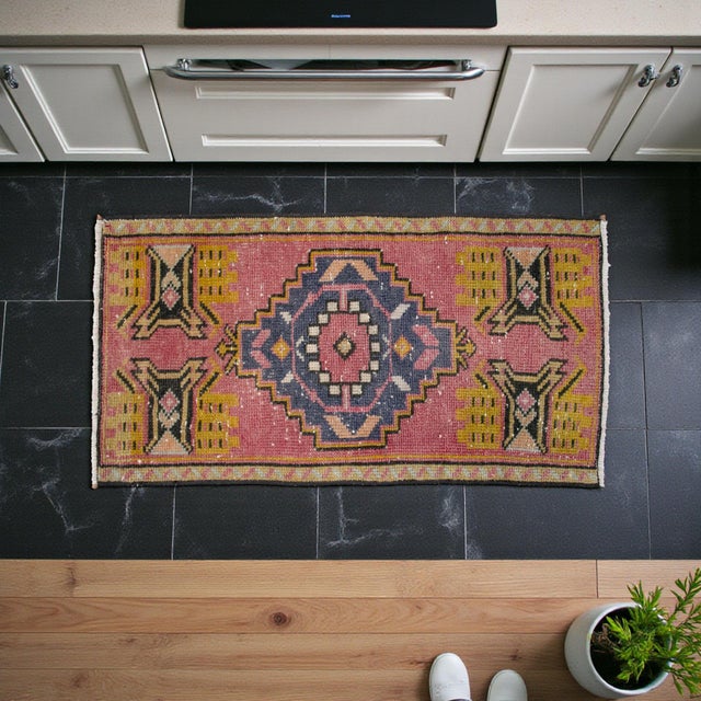 This authentic vintage Turkish Oushak rug showcases a delightful harmony of weathered pink tones and tribal geometric...