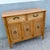 A charming Boho Chic sideboard by Broyhill featuring warm oak-toned wood, faux bamboo detailing, and woven wicker drawer...