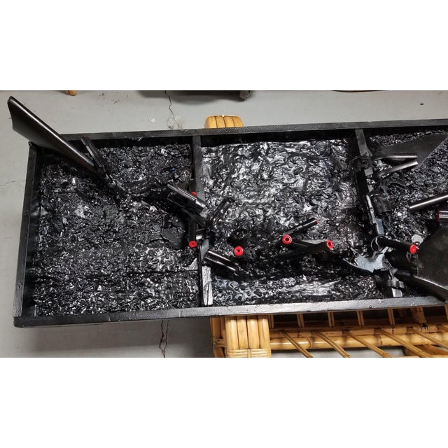 Black and red artillery artography wall sculpture featuring repurposed fragments of shotguns, rifles, and gun barrels by...