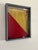 1940s era red and yellow signal flag framed in a newer gray shadow box with a portion of its original painted pole.