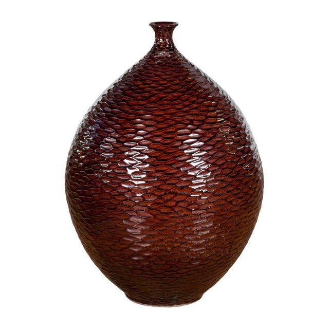 A Prem Collection ceramic handcrafted vase with burgundy brown textured finish, teardrop shape, honeycomb style motifs and...