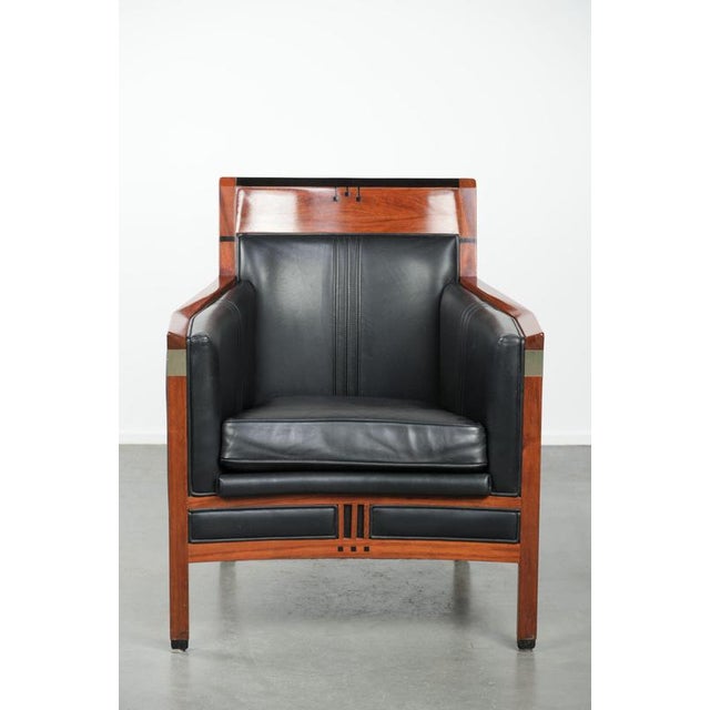 We are offering this black leather and wood Art Deco armchair by Schuitema from the Decoforma series. A piece of furniture...