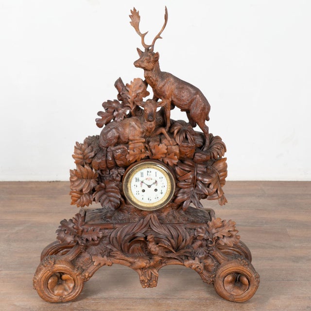 This antique Black Forest carved mantel game clock was hand-carved in Germany during the 19th century. The detailed linden...