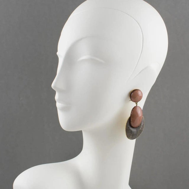 Cilea Paris designed these elegant clip-on earrings. These dimensionally dangling artisanal resin earrings feature a...