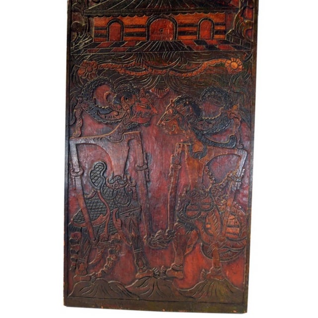 An Indonesian hand-carved wooden puppet show sign with red and black painted accents from the early 20th century. This...
