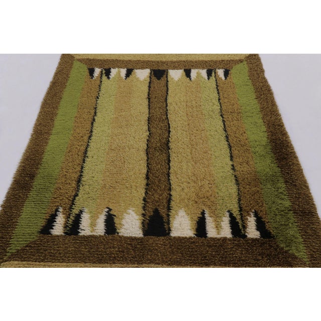 Hand-knotted in lush, high-pile wool in Sweden circa 1960-1970, this 5x7 vintage Swedish Rya rug is a bold new addition to...