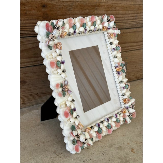 Beautiful handmade seashell picture frame adorned with pops of color and natural seashells. Frame can hold a 5x7 with mat...