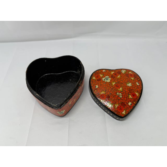 A charming vintage Kashmiri heart-shaped paper mâché box, exquisitely hand-painted with vibrant floral decorations. This...
