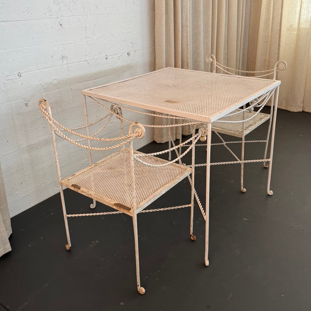 This lovely mid-century Hollywood Regency patio dining set pairs a square dining table with two matching armchairs in an...