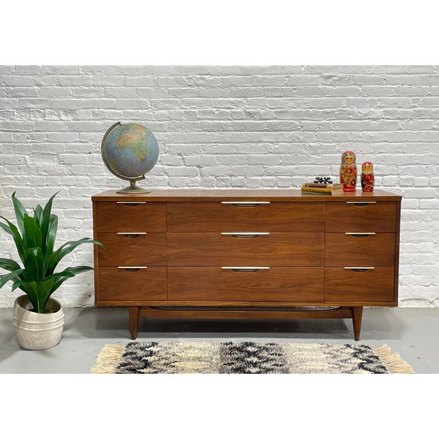 Mid Century Modern Walnut Triple Dresser by Kent Coffey's Tableau Line, circa 1960's. This lovely piece features NINE deep...
