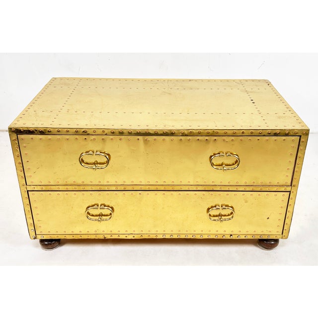 Brass clad chest of two drawers, functional as a coffee or cocktail table, on bun feet. Made by Sarreid Spain, circa 1970s.