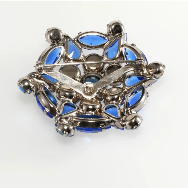 Richly colored vintage brooch comprised of rhinestones in several shades of blue. The iridescent stones are foiled for...
