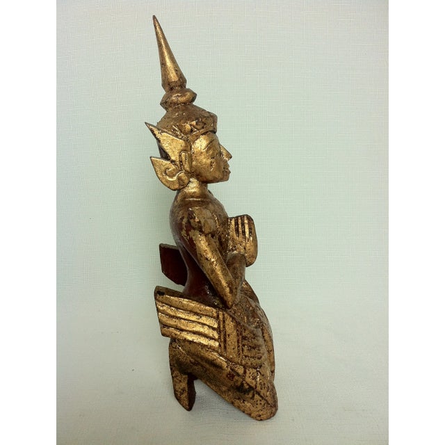 Thai reddish-gold giltwood figure of a seated buddha in ornate costume and headdress