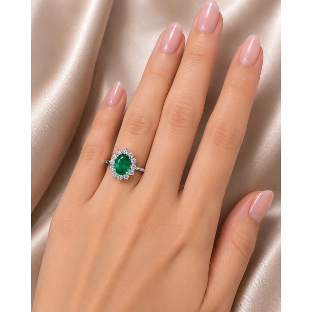 Metal: 18K White Gold Primary Stone: Natural Oval Emerald 1.1 CT Accent Stones: 12 Round Brilliant Diamonds 0.4 CT Ring...