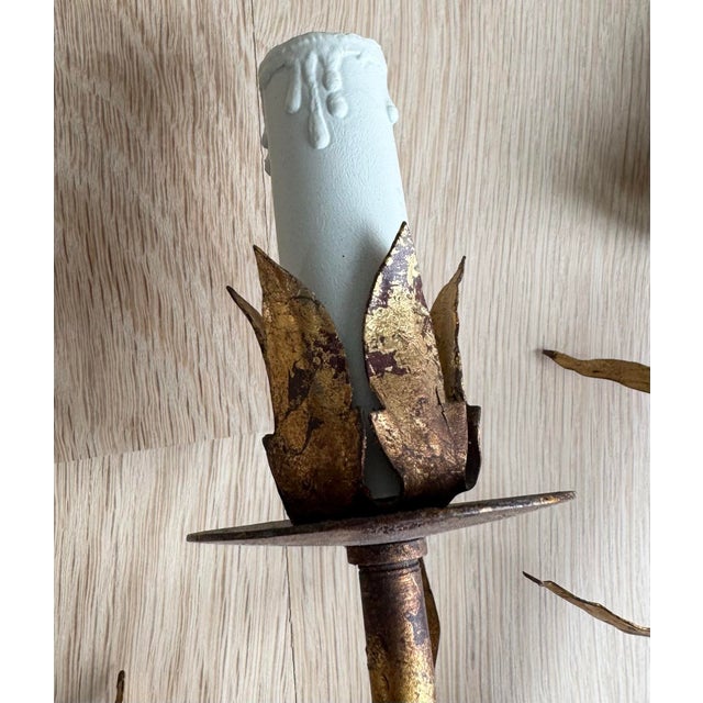 A sophisticated pair of mid-century Italian Toleware wall sconces. They feature an elegant botanical design with...