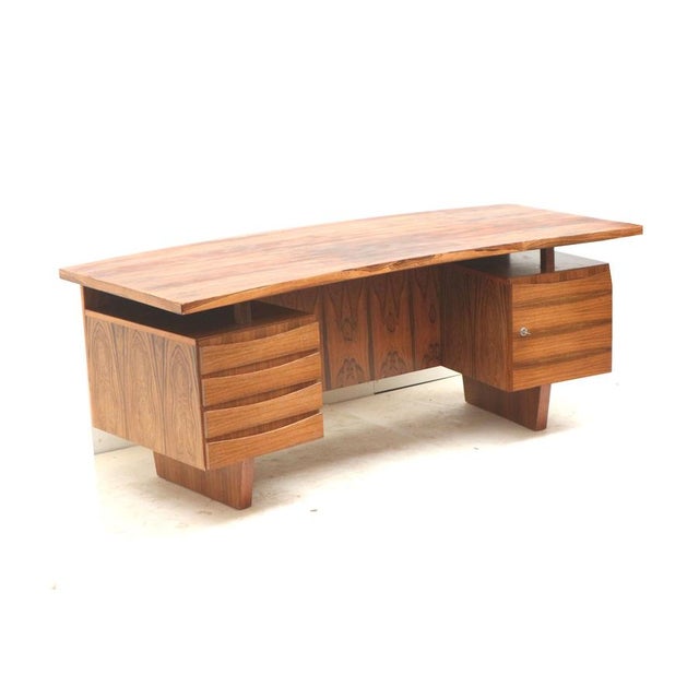 Large rosewood boomerang desk / executive desk from the 1960s. This large vintage boomerang desk from the 1960s is a...