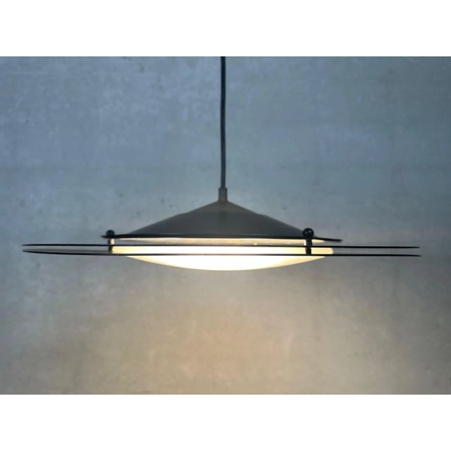 Vintage 80s/90s pendant lamp. Model: UFO. Two metal saucers are held apart by spacers. Conical, ascending section with...