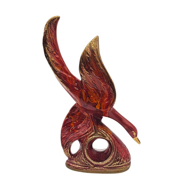 It arches like fire frozen mid-flight, a phoenix born not of myth but glaze. Glints of orange and red dance beneath gold...