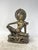 A refined bronze sculpture depicting the god Indra seated in a regal pose. A collector's item of oriental art.