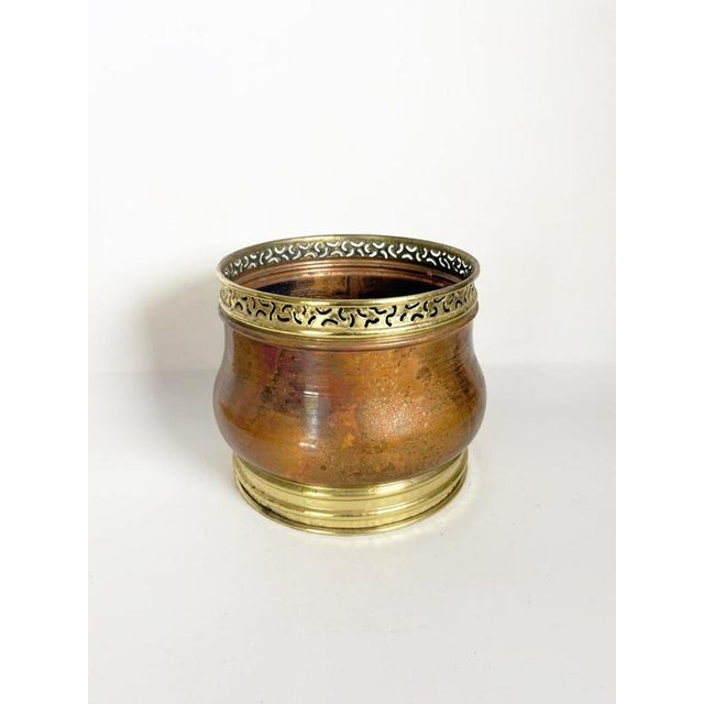 Decorative French planter dating from the 1970s, featuring a rounded metal body with warm copper-brown tones and...