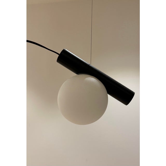 The Node Chandelier uses the language of circles to present a delicate imbalance. A glass sphere traces its perimeter...