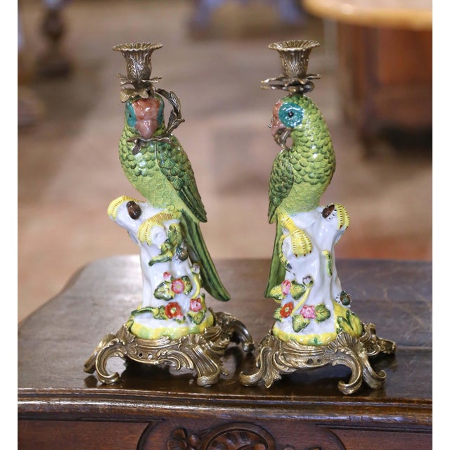 Pair of antique porcelain and ormolu parrot candlesticks crafted in China circa 1950. Each sculptural piece features a...